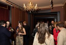 Guests in a red-walled room with a crystal chandelier at Adelphi Art House
