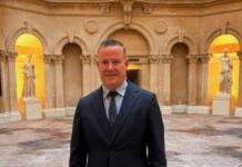Adam Flint, General Manager of Bristol Marriott Royal Hotel, in a dark suit in front of arched stone niches with classical statues