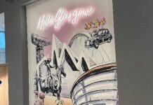 The ‘Hello Glasgow’ mural in the Glasgow Marriott Hotel lobby, with a neon sign above drawings of the Finnieston Crane, Riverside Museum, OVO Hydro, the Duke of Wellington statue and a black cab lifted by balloons