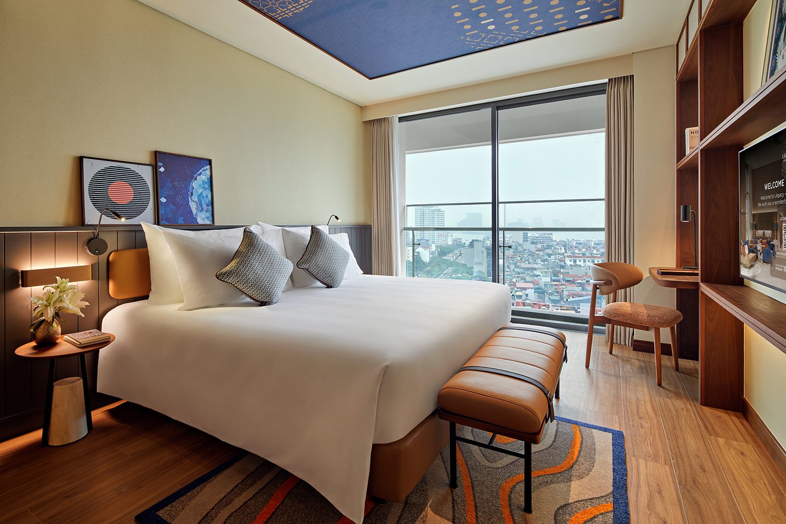 Original Room at LÈGACY Hanoi, with a double bed and floor-to-ceiling windows to the balcony