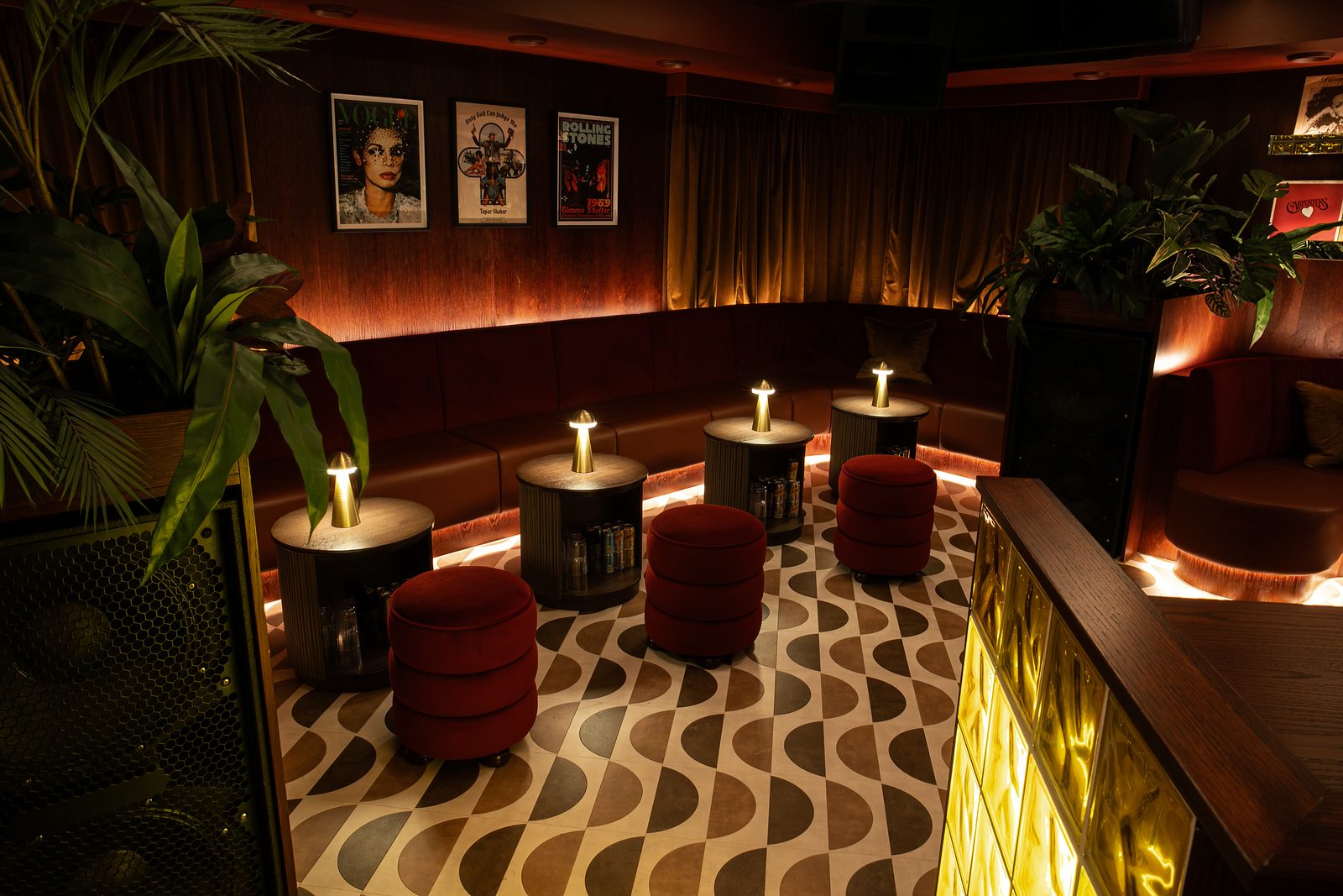 Low tables and red stools on a patterned floor in The Vinyl Room at NinetyNine Regent Street