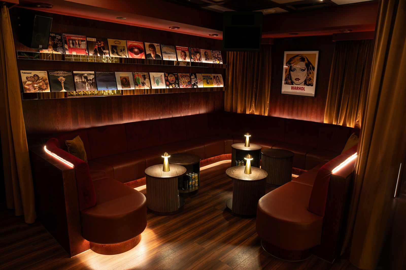 Banquette seating beneath a wall of record sleeves at NinetyNine Regent Street