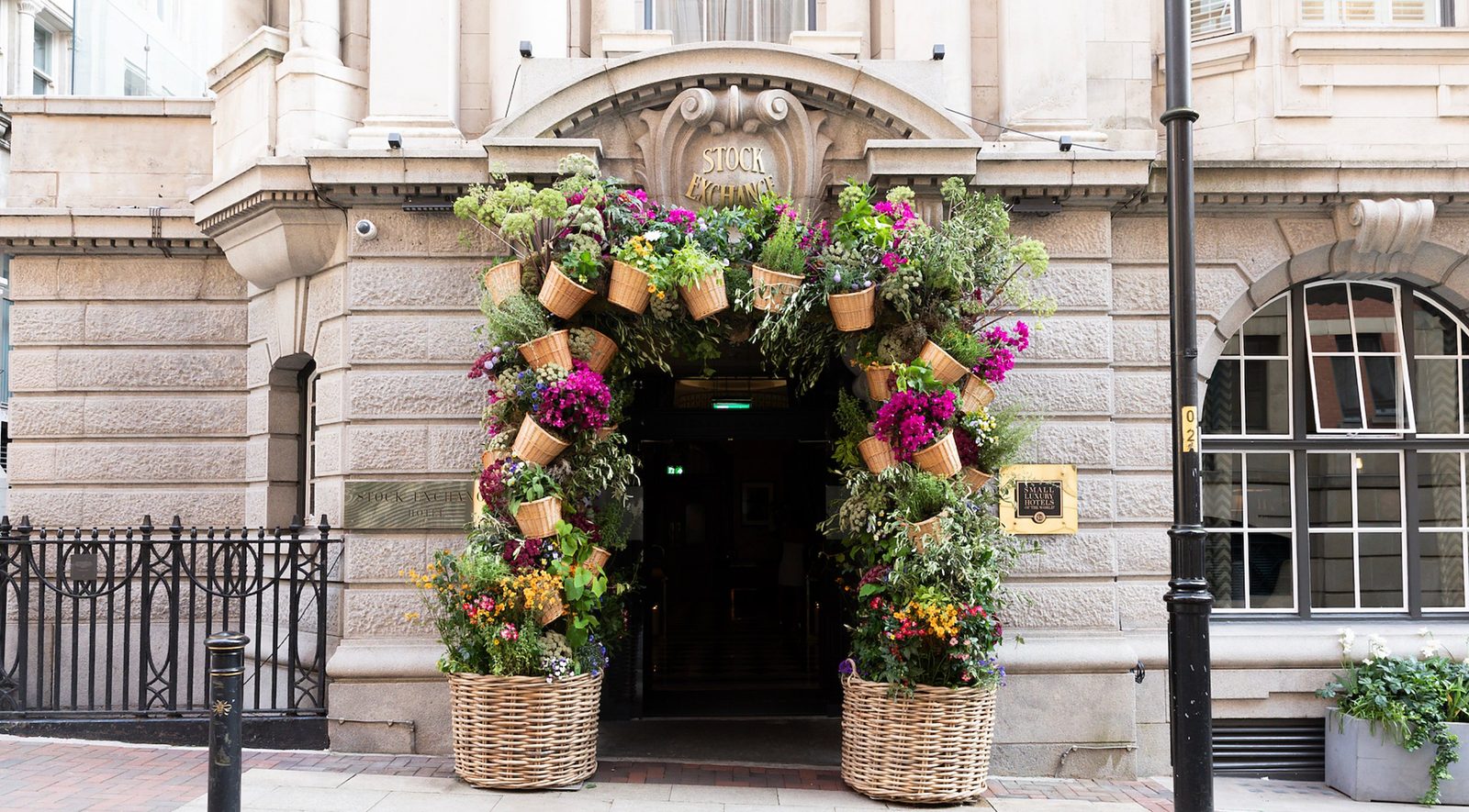The entrance to the Stock Exchange Hotel in Manchester framed by an arch of flowers and wicker baskets